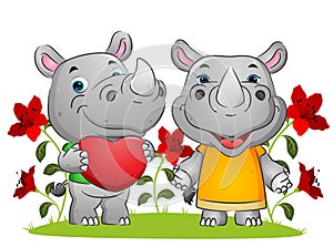 The couple of happy rhino expressing love on the valentine day in the garden