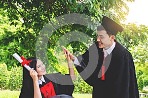Couple happy smiling graduates, Woman students friends in graduation gowns holding diplomas and congratulate each other
