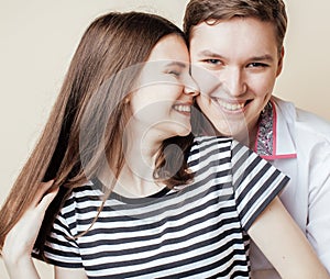 Couple of happy smiling teenagers students, warm colors having a kiss, lifestyle people concept