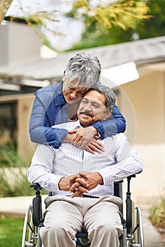 Couple, happy woman and senior man with wheelchair in backyard for care, love or bonding. Retirement, female pensioner