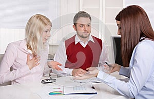 Couple has consultation with consultant at desk.