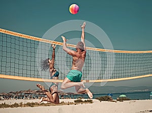 Couple have fun playing volleyball. Young sporty active couple beat off volley ball, play game on summer day.