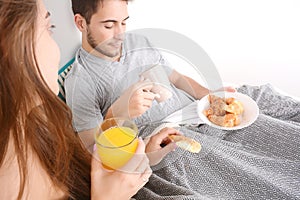 Couple having breakfast in bed.