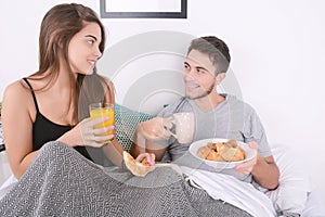 Couple having breakfast in bed.