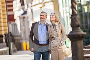 Couple having city break in summer walking on street.