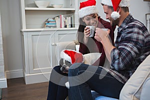 Couple having coffee with their pet dog in living room