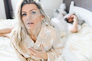 Couple having crisis in bed. Woman sitting on bed`s edge