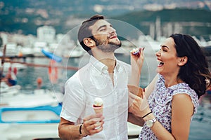 Couple having date and eating ice cream on vacation. Sea background