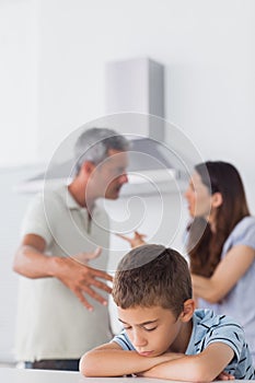 Couple having dispute in front of their sad son