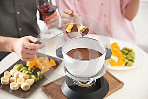 Couple having fondue dinner at table