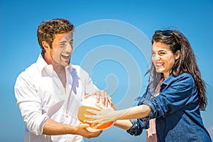 Couple having fun with a beach ball