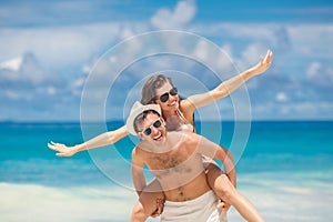 Couple having fun on the beach of a tropical ocean.