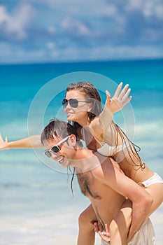 Couple having fun on the beach of a tropical ocean.