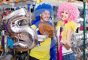 Couple is having fun in colorful clown wigs