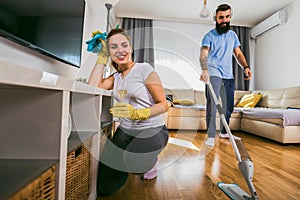 Couple having fun while doing spring cleaning