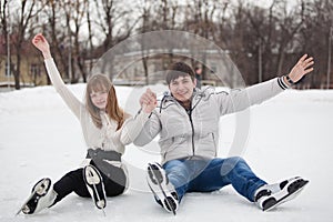 Couple having fun on ice skate rink outdoors.