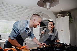 Couple having fun, laughing in the kitchen and cooking together