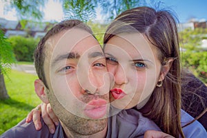 Couple having fun making duckface and taking selfie picture in t