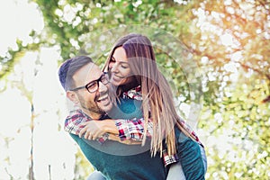 Couple having fun man giving piggyback to woman