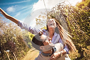 Couple having fun man giving piggyback to woman