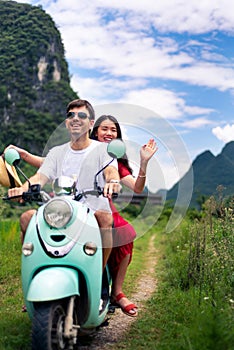 Couple having fun on motorbike around rice fields in China