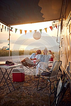 Couple having fun outdoors.Cheerful man and woman Partying Near Modern Camper Van In Camping