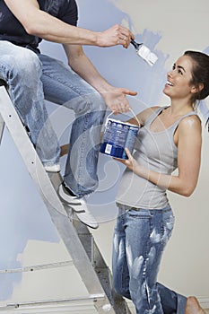 Couple Having Fun While Painting Unrenovated House photo