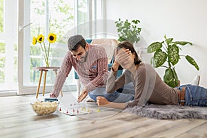 Couple having fun playing ludo board game