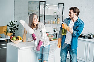 couple having fun with spray bottle and dust brush during photo