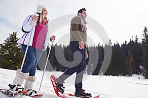 Couple having fun and walking in snow shoes