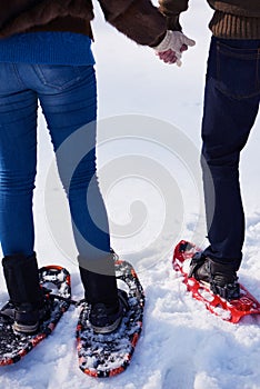 Couple having fun and walking in snow shoes