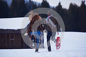 Couple having fun and walking in snow shoes