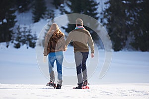 Couple having fun and walking in snow shoes