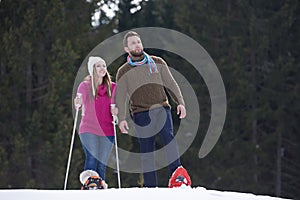 Couple having fun and walking in snow shoes