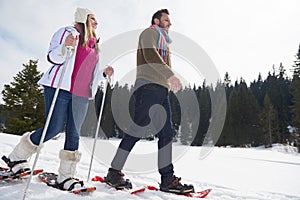 Couple having fun and walking in snow shoes