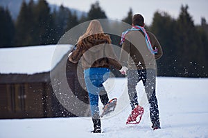 Couple having fun and walking in snow shoes