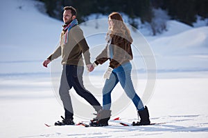Couple having fun and walking in snow shoes