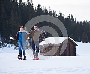 Couple having fun and walking in snow shoes