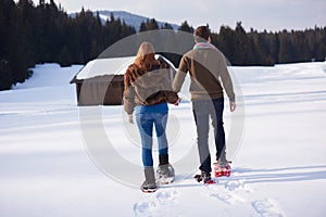 Couple having fun and walking in snow shoes