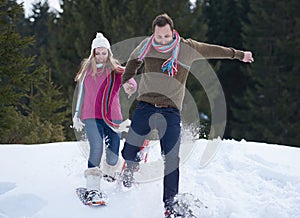 Couple having fun and walking in snow shoes