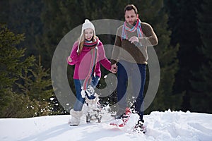 Couple having fun and walking in snow shoes