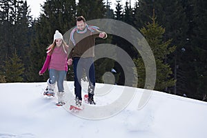 Couple having fun and walking in snow shoes