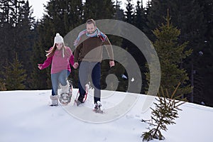 Couple having fun and walking in snow shoes