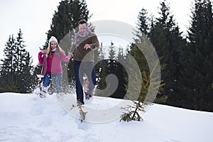 Couple having fun and walking in snow shoes