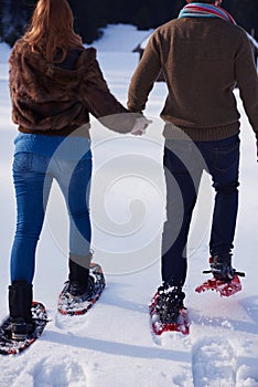 Couple having fun and walking in snow shoes