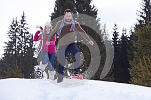 Couple having fun and walking in snow shoes