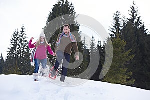 Couple having fun and walking in snow shoes