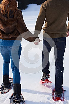 Couple having fun and walking in snow shoes