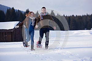 Couple having fun and walking in snow shoes
