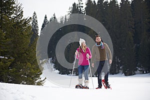 Couple having fun and walking in snow shoes